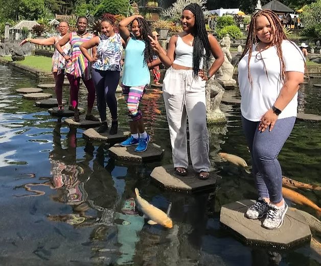 A group of travelers on stepping stones at a Bali water garden